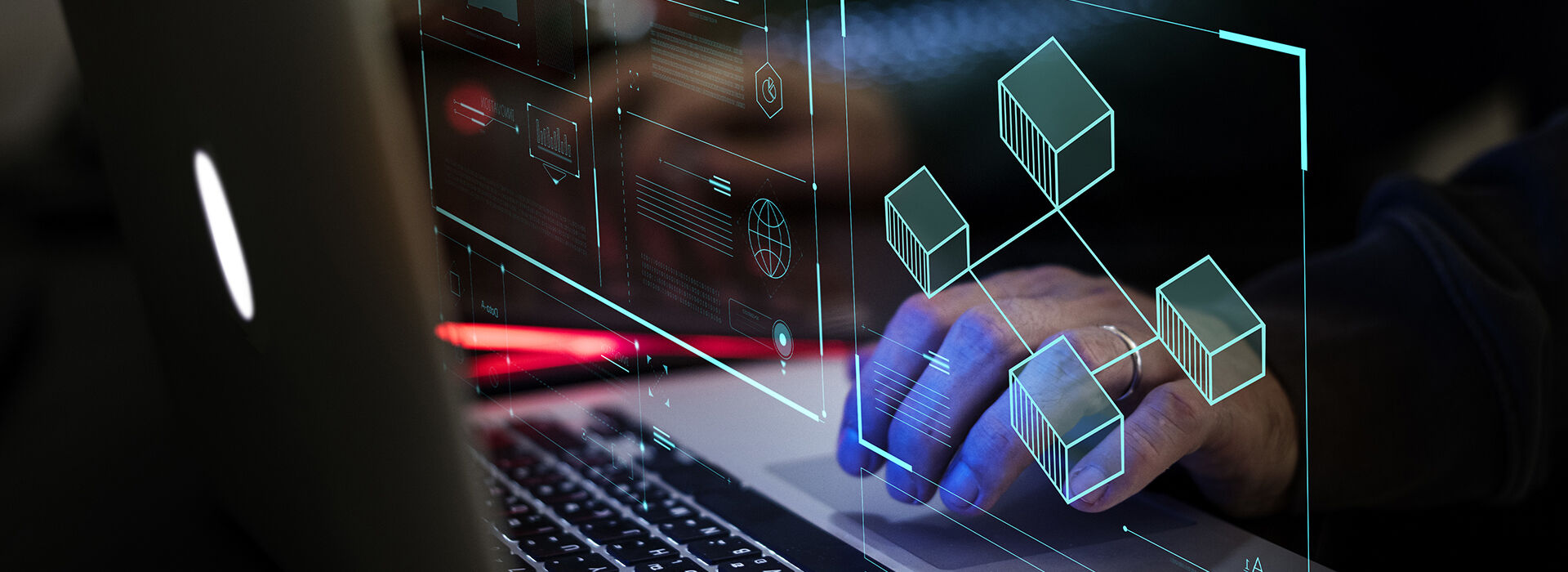 Person working on a laptop with holographic digital asset data blocks floating above the keyboard